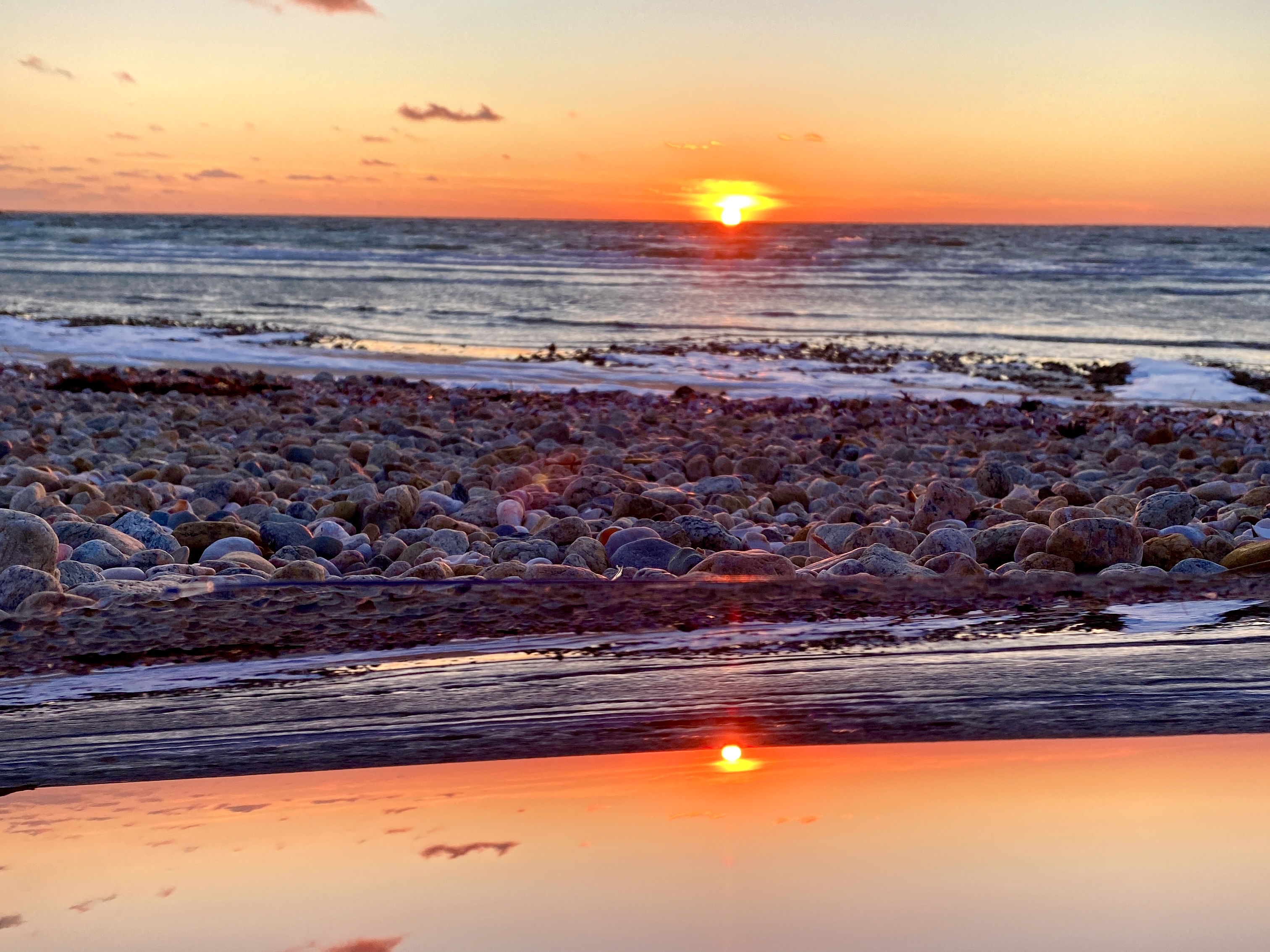Sunset reflected in a calm shoreline pool